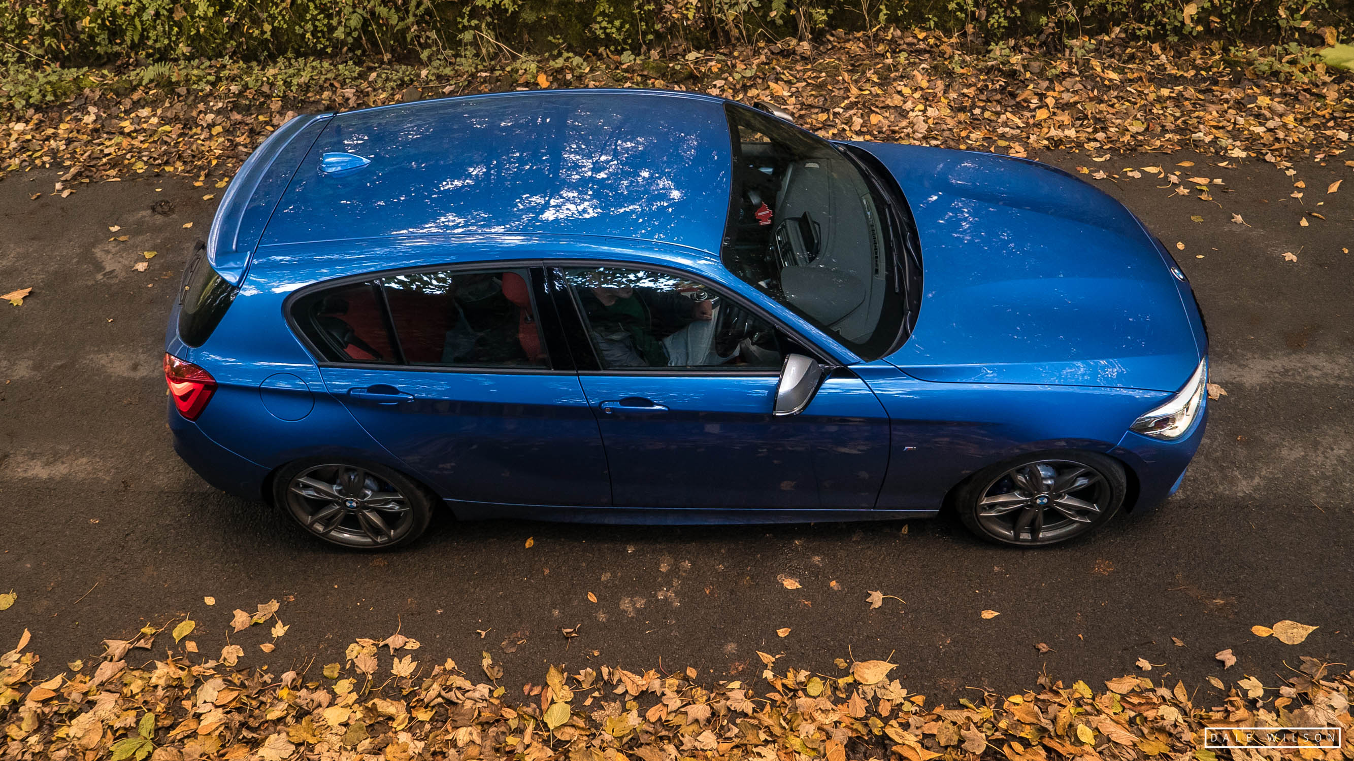 An Estoril blue BMW 135i in autumn leaves cumbria
